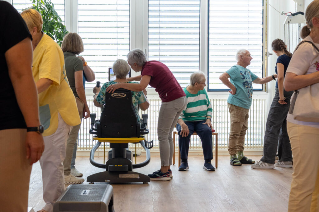 Bewohner testet gemeinsam mit Aktivierungsfachkraft verschiedene Geräte in der neuen Fitnessarena.
